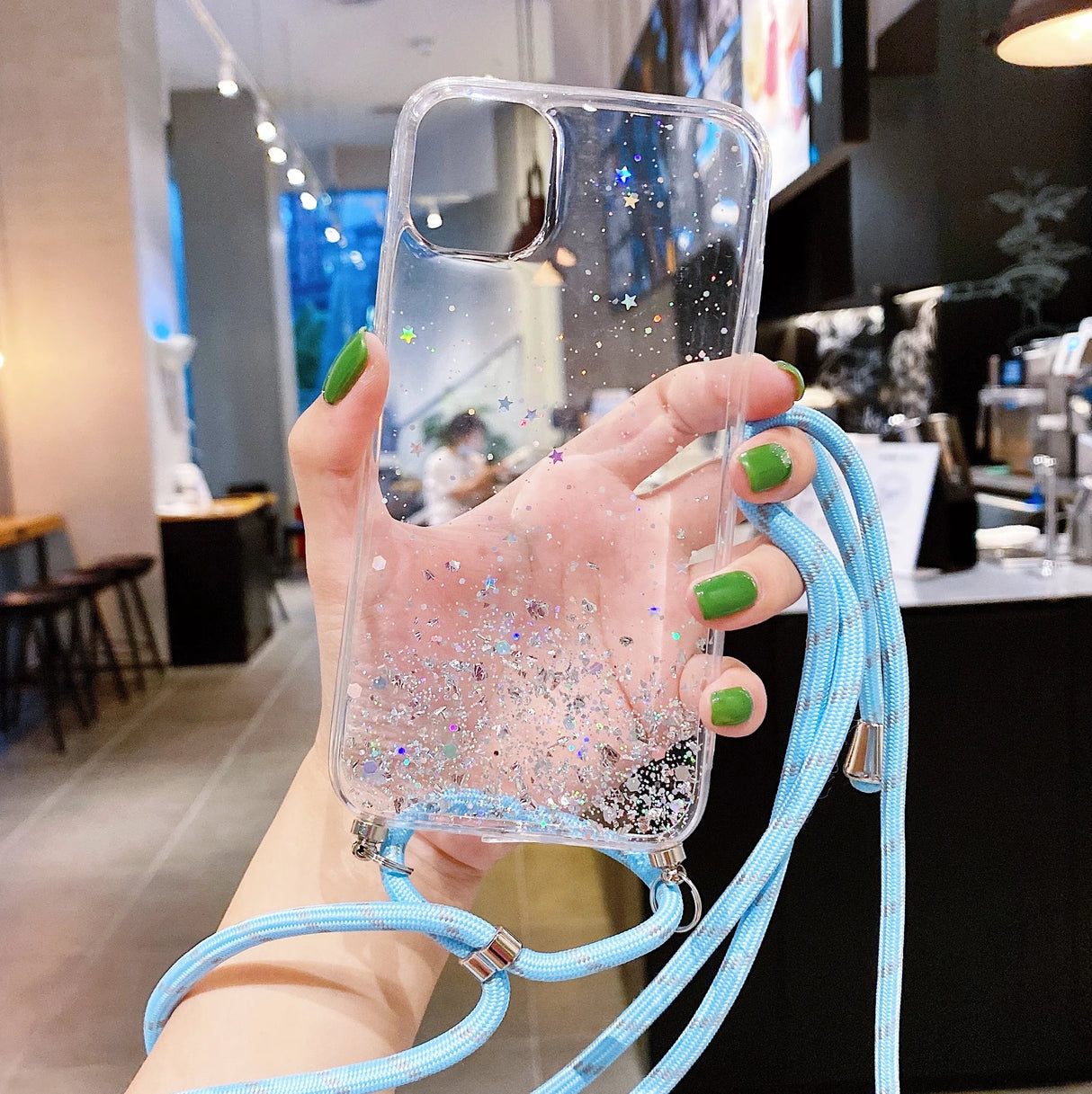 Clear smartphone case with glitter and an attached blue lanyard.