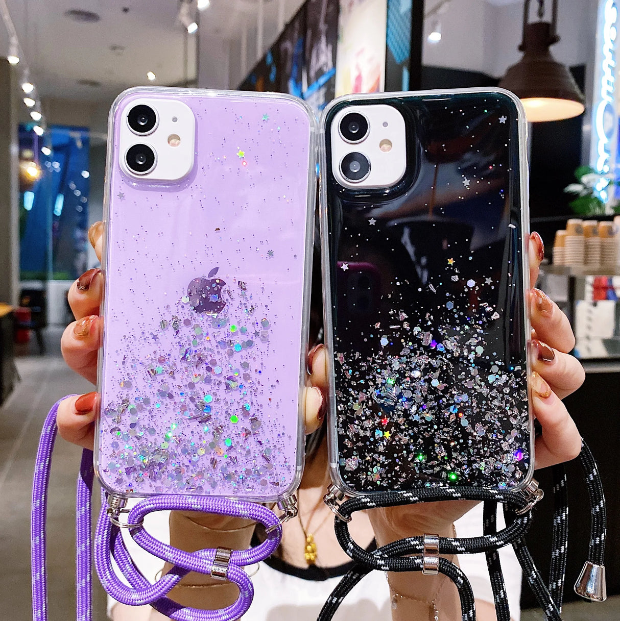 Two glittery phone cases with lanyards, one purple and one black.