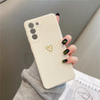 Cream-colored phone case with a gold heart design and three camera cutouts.