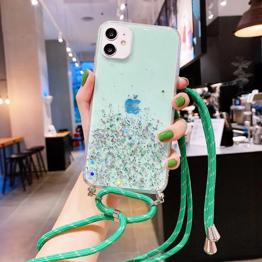 Mint green iPhone with a glitter case and green lanyard.