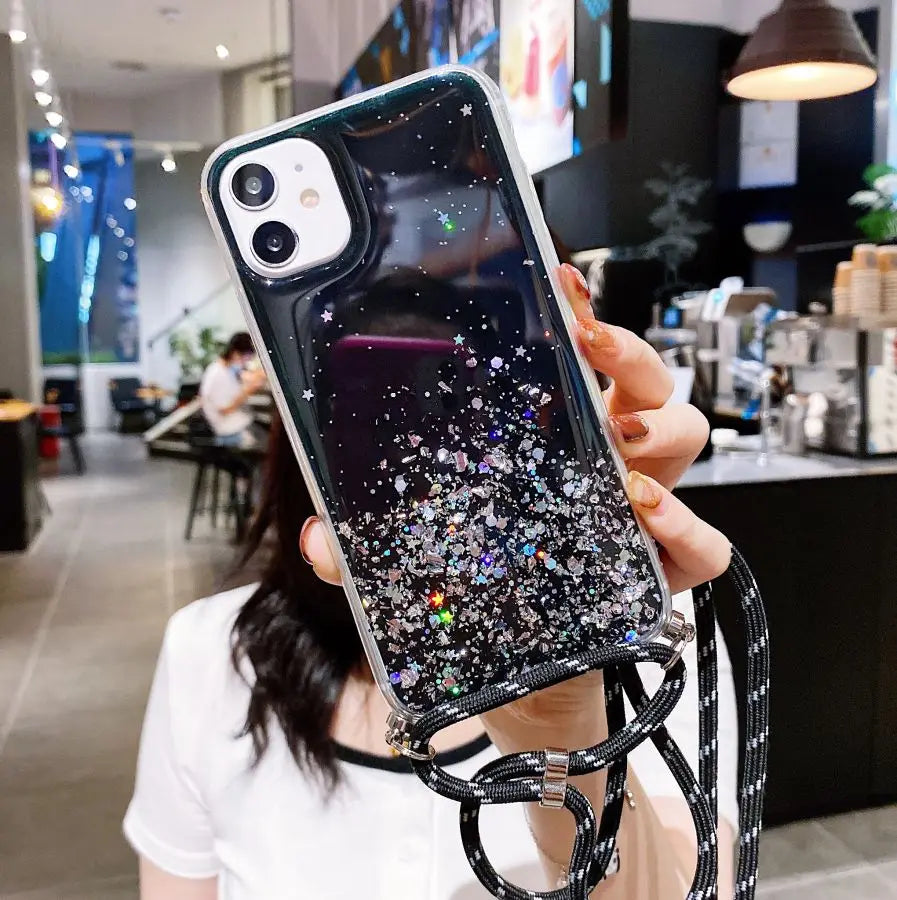 Glittery black iPhone case with a black and white lanyard.