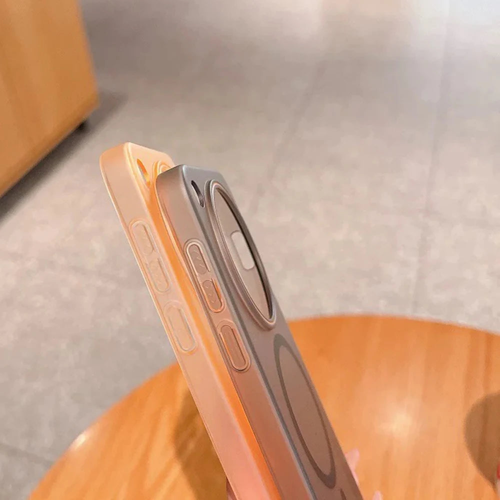 Two translucent phone cases, one peach and one grey, with visible MagSafe rings and side buttons.