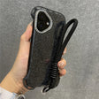 Glittery black phone case with a diamond-studded camera bezel and a black wrist lanyard.