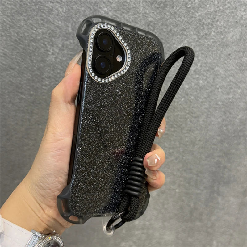 Glittery black phone case with a diamond-studded camera bezel and a black wrist lanyard.
