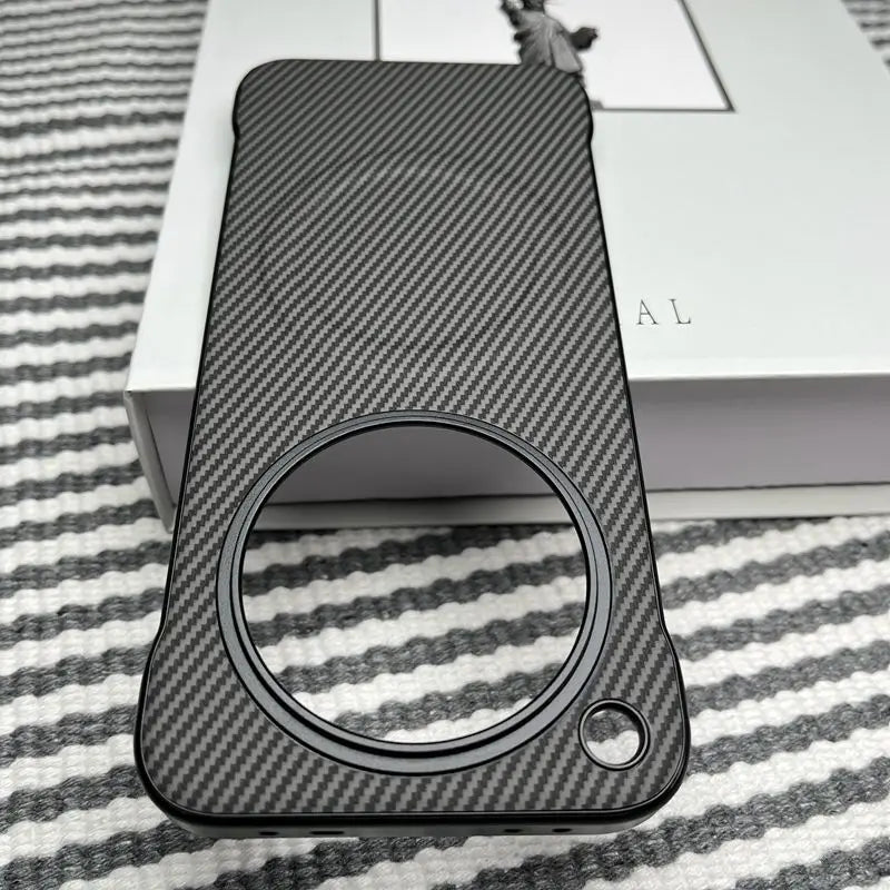 A smartphone case with a carbon fiber texture and a large circular cutout for the camera module.