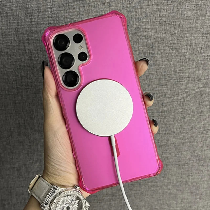 Pink smartphone in a clear case with a white circular wireless charger attached.