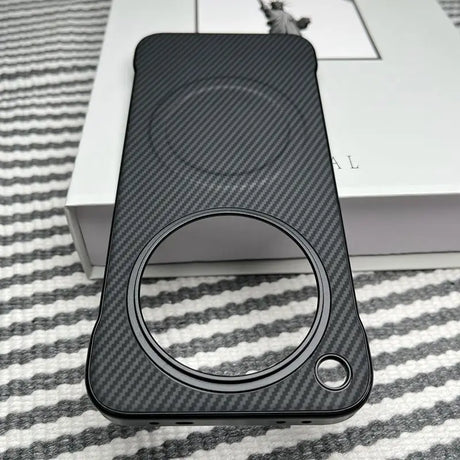 Black carbon fiber phone case with a large circular cutout and a smaller circular cutout.