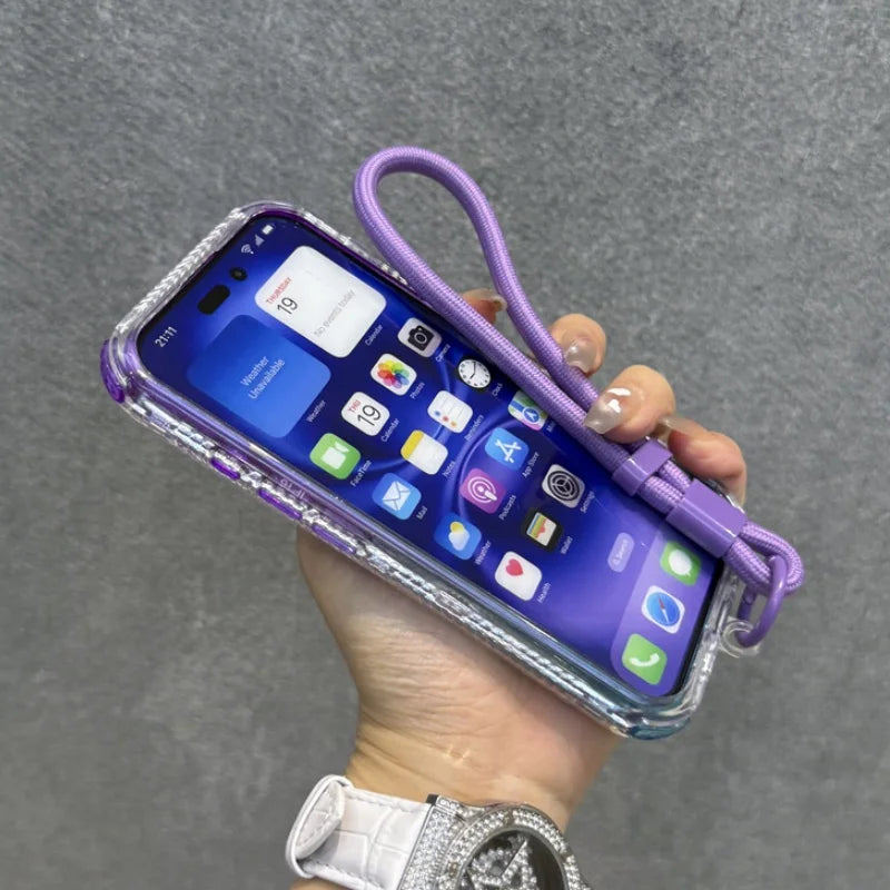 Purple iPhone 14 Pro Max with a clear, sparkly case and an attached purple wrist strap.