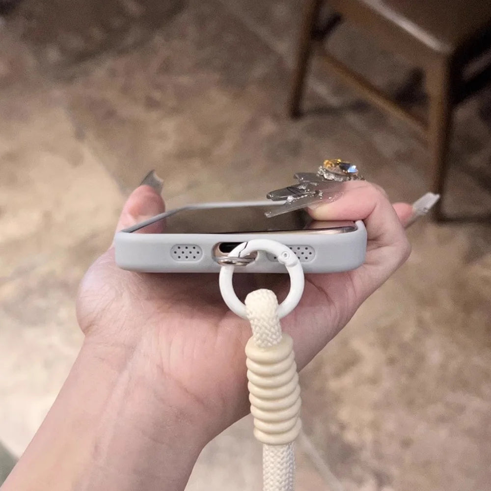 A light gray phone case with a white lanyard attached.