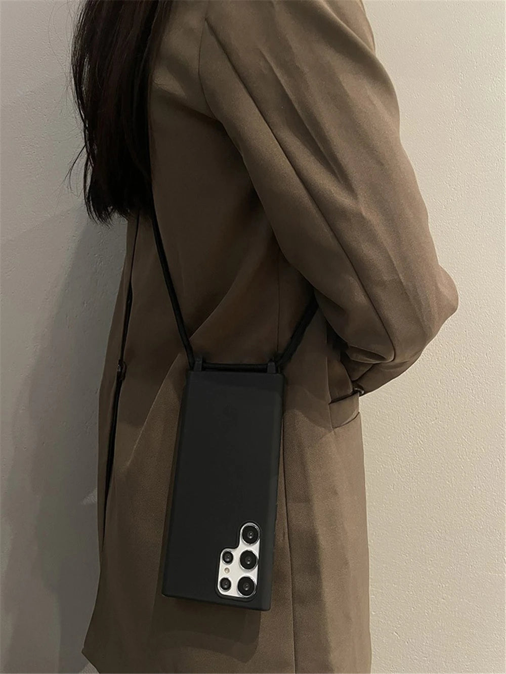 A black smartphone case with a shoulder strap, featuring multiple camera lenses on the back.