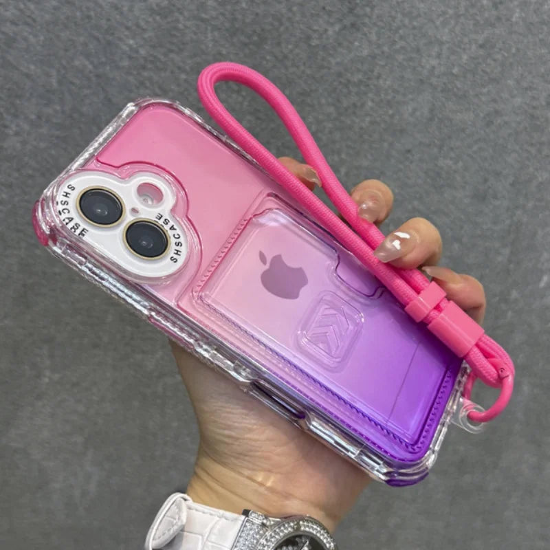 Pink and purple gradient iPhone case with a clear frame, a built-in card holder, and an attached pink wrist strap.