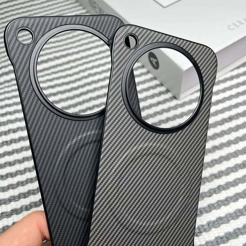 Two carbon fiber phone cases with circular camera cutouts.