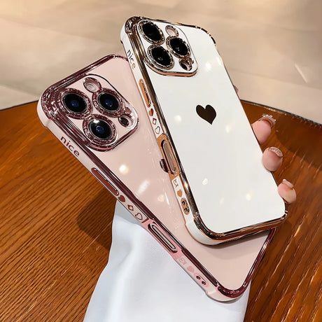 Two rose gold and white iPhone cases with heart designs.