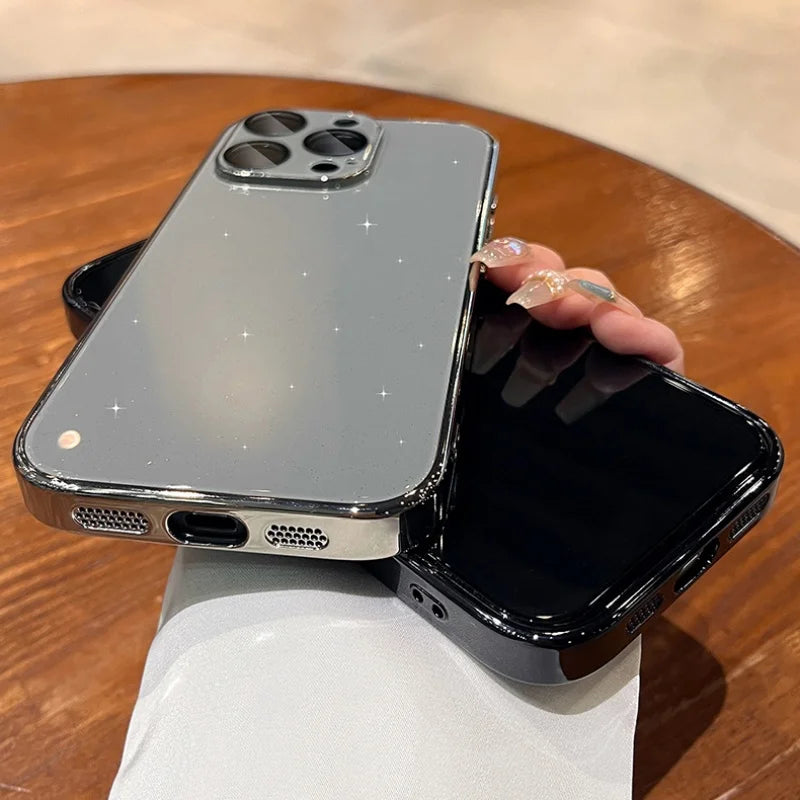Two smartphone cases, one clear with glitter and chrome edges, and one solid black.