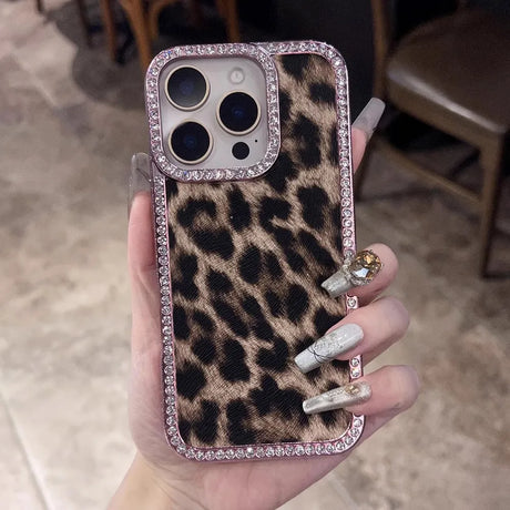 Leopard print phone case with a jeweled camera bezel and rhinestone border.