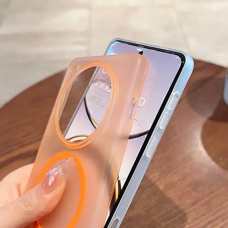 A translucent orange phone case with a large circular cutout for cameras and a smaller magnetic ring, being held next to a smartphone.
