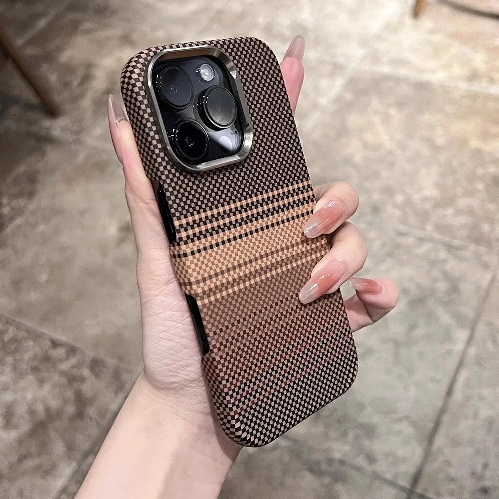 A person’s hand holding a phone case with a black and brown checkered pattern and a metallic camera bezel.