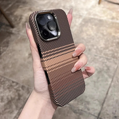 A person’s hand holding a phone case with a black and brown checkered pattern and a metallic camera bezel.
