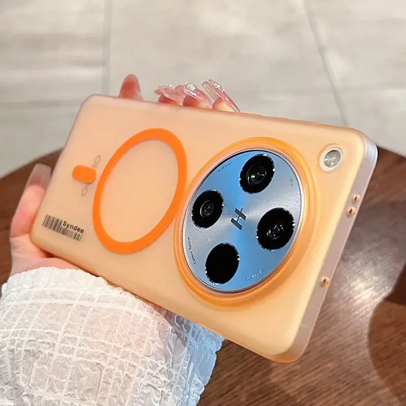 A peach-colored translucent phone case with an orange circular magnet and a camera lens protector.