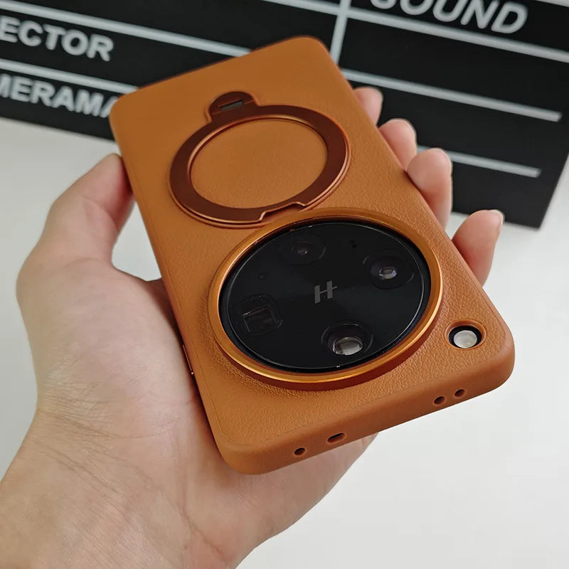 Brown leatherette phone case with an integrated ring holder and a prominent circular camera cutout.