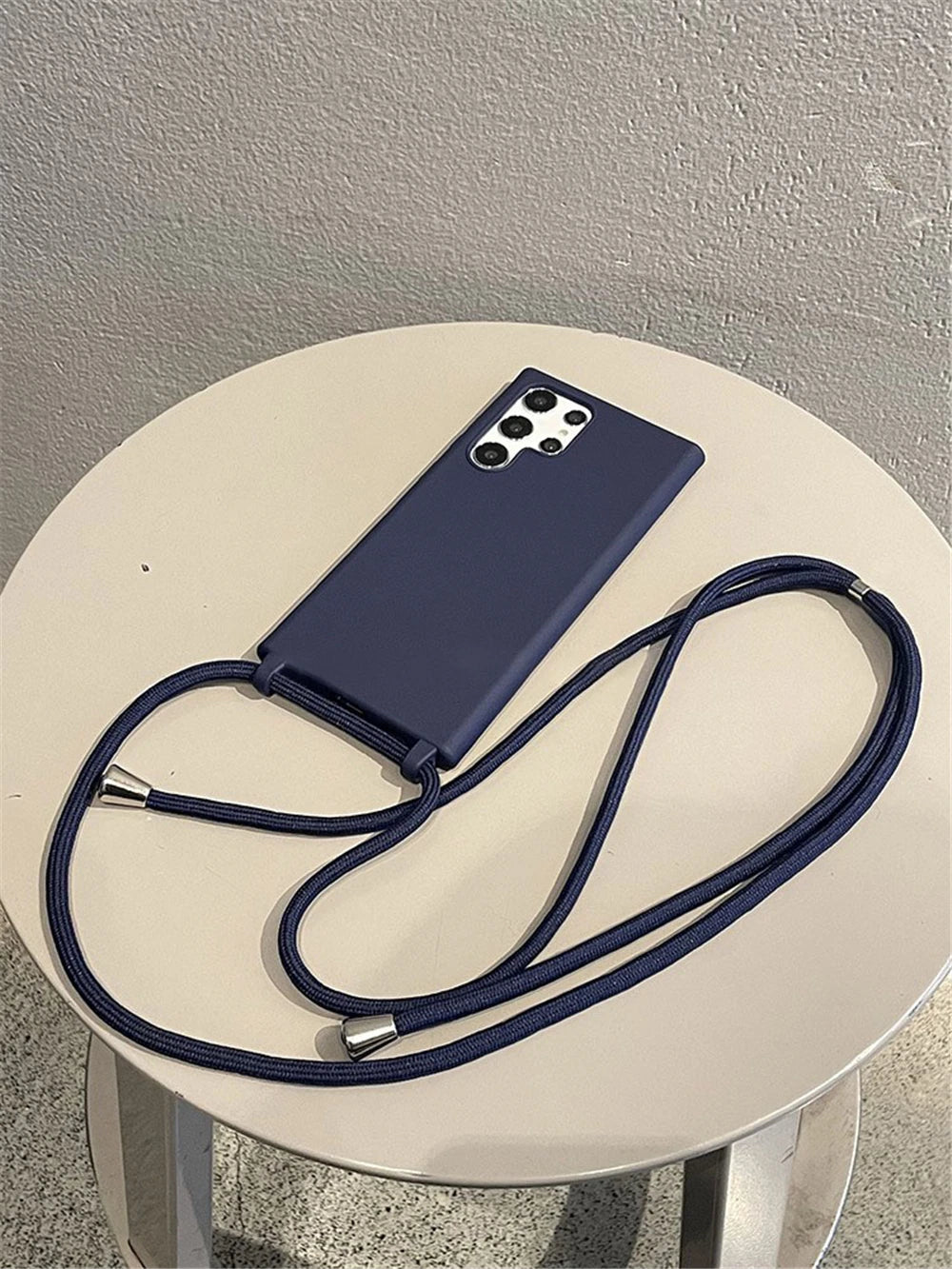 Dark blue smartphone case with an attached lanyard.
