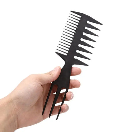 someone holding a black comb in their hand on a white background