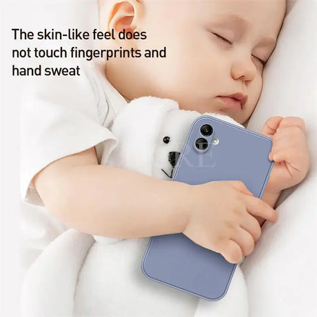 a baby sleeping on a bed with a phone
