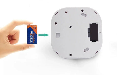 Battery being inserted into a white device.