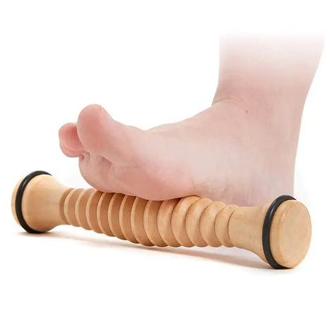 a person’s foot with a wooden roller