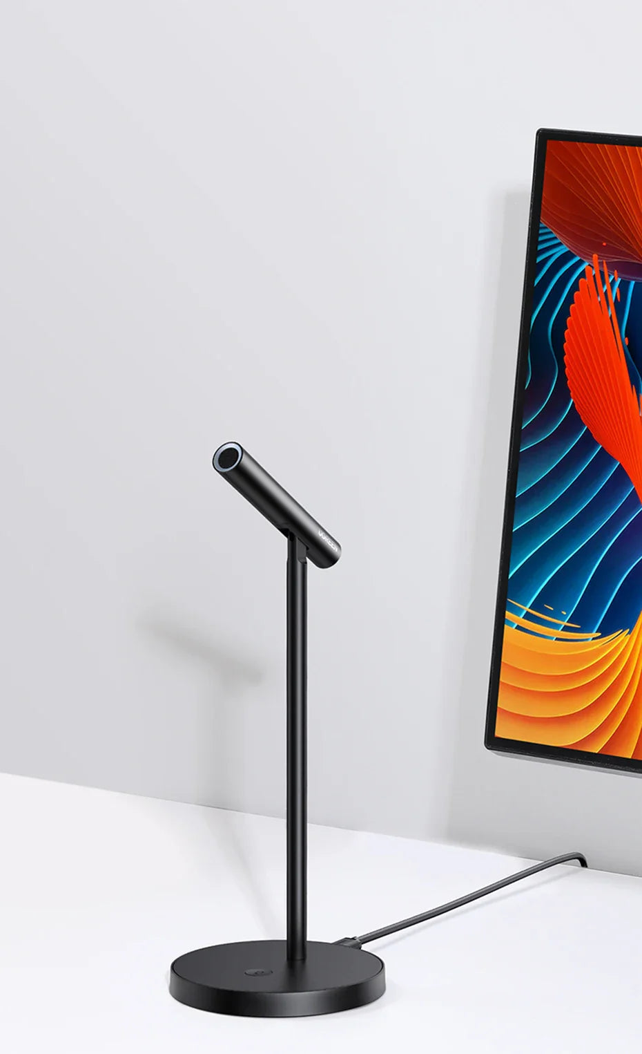 Black desk lamp with a slender adjustable arm and circular base.