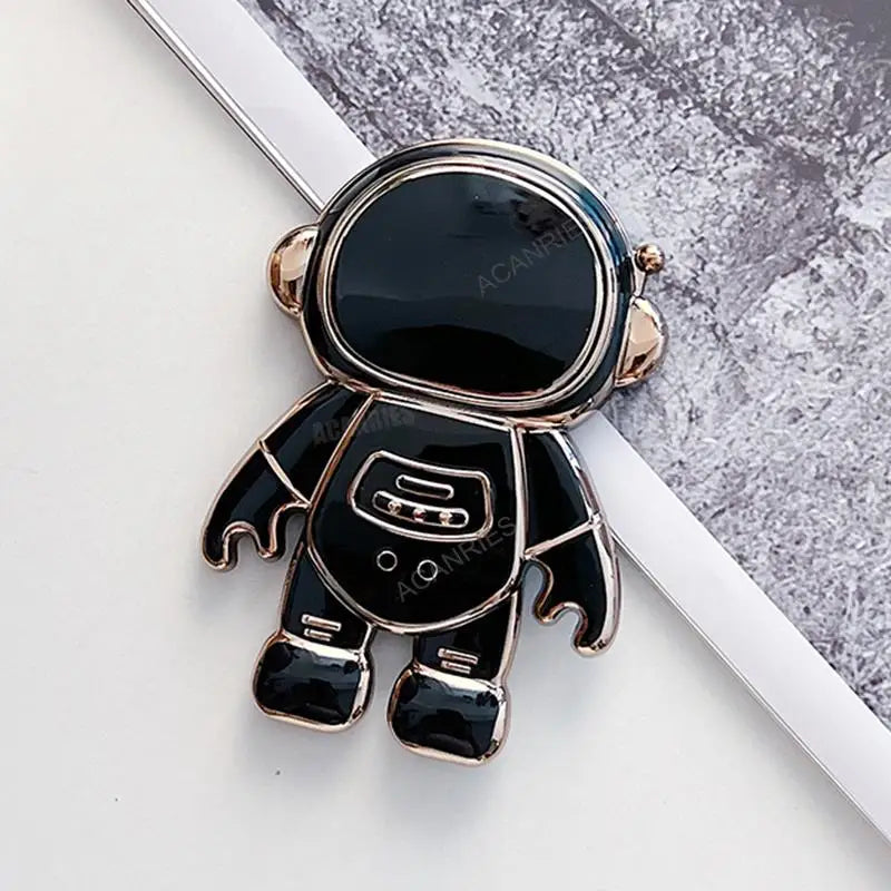 a black and gold astronaut charm with a white background