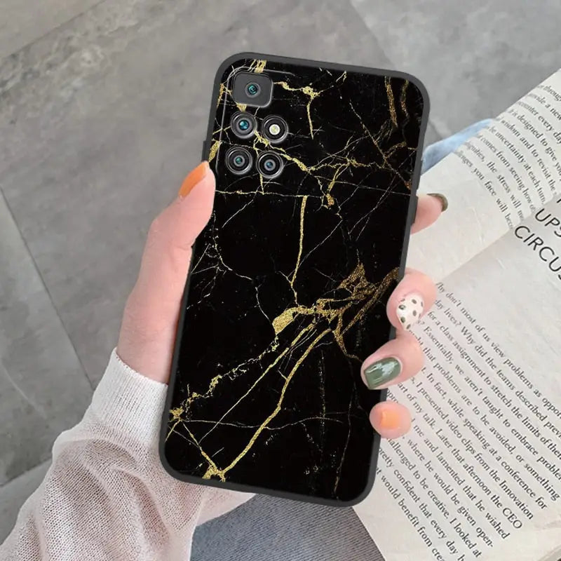 a woman holding a book and a black marble phone case