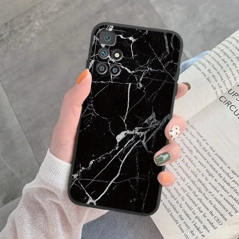 a woman holding a book and a black marble phone case