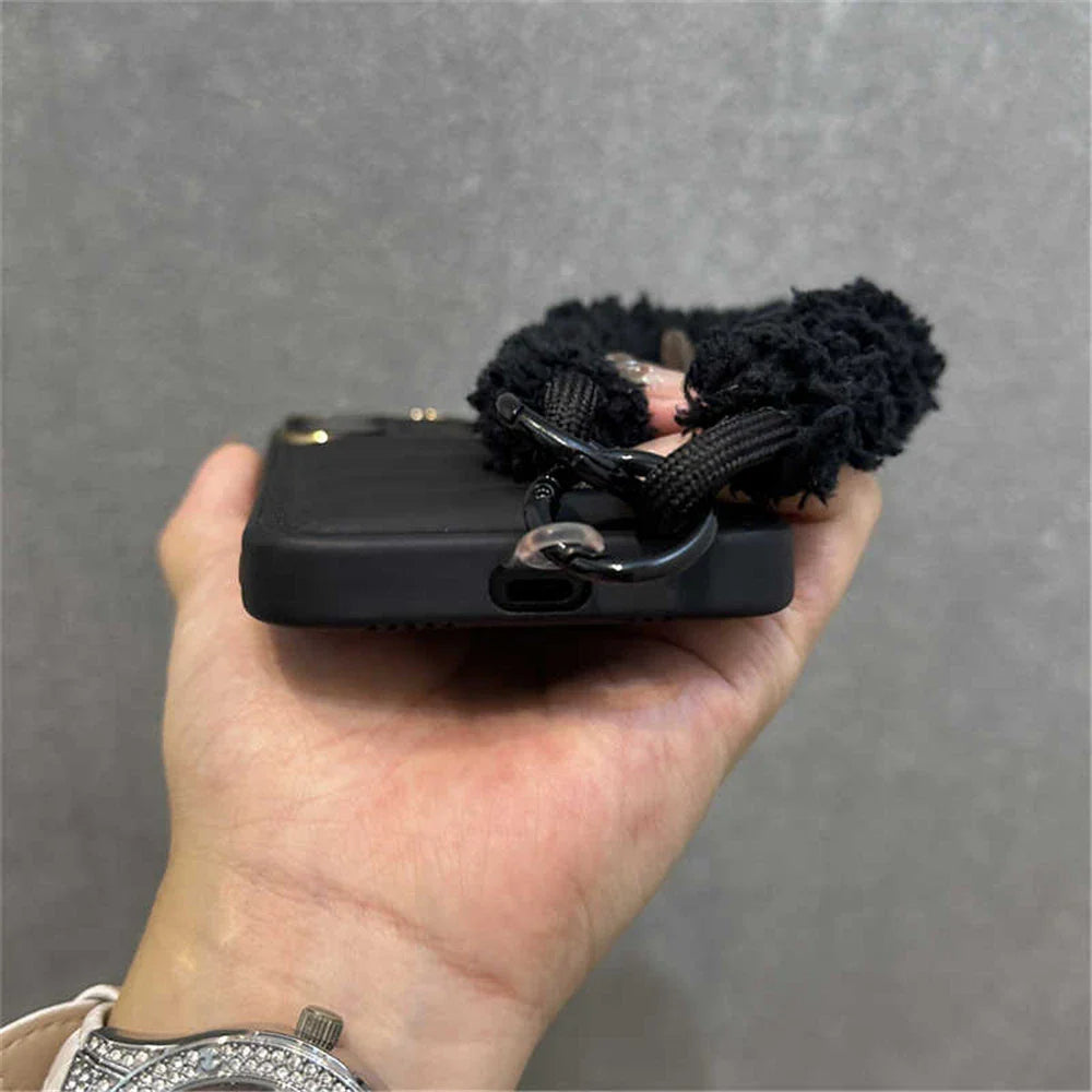 Black phone case with fluffy wrist strap.