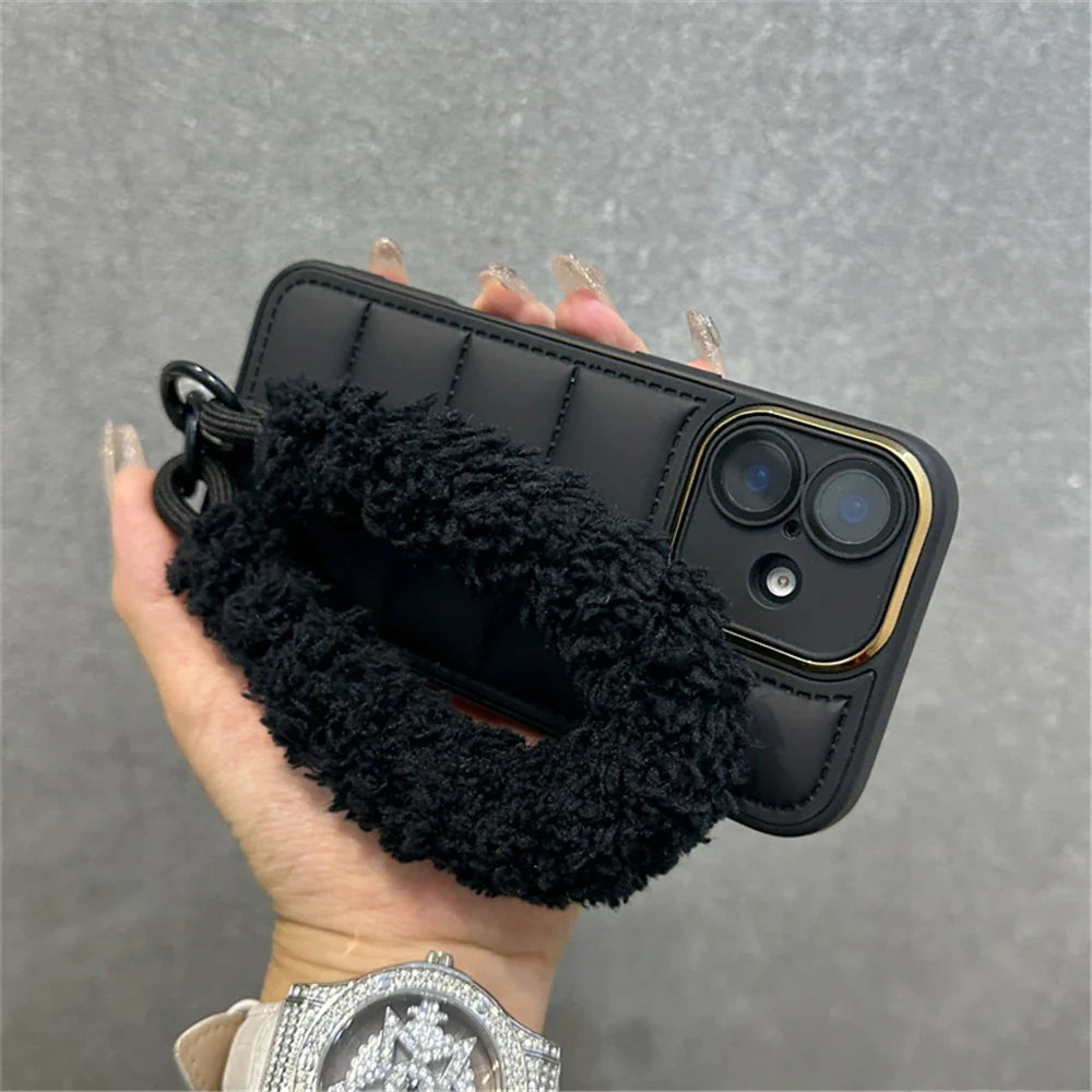 Black quilted phone case with fuzzy wrist strap.