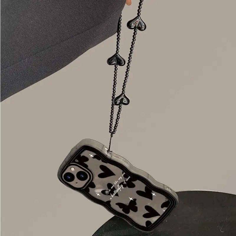 a black and white cell phone case with a chain