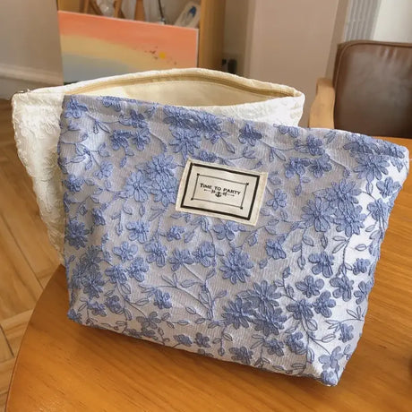 a blue and white floral bag on a wooden table