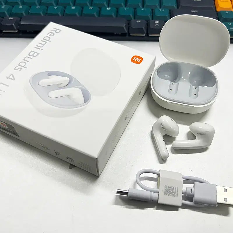 There is a box with earphones and a charger on a desk