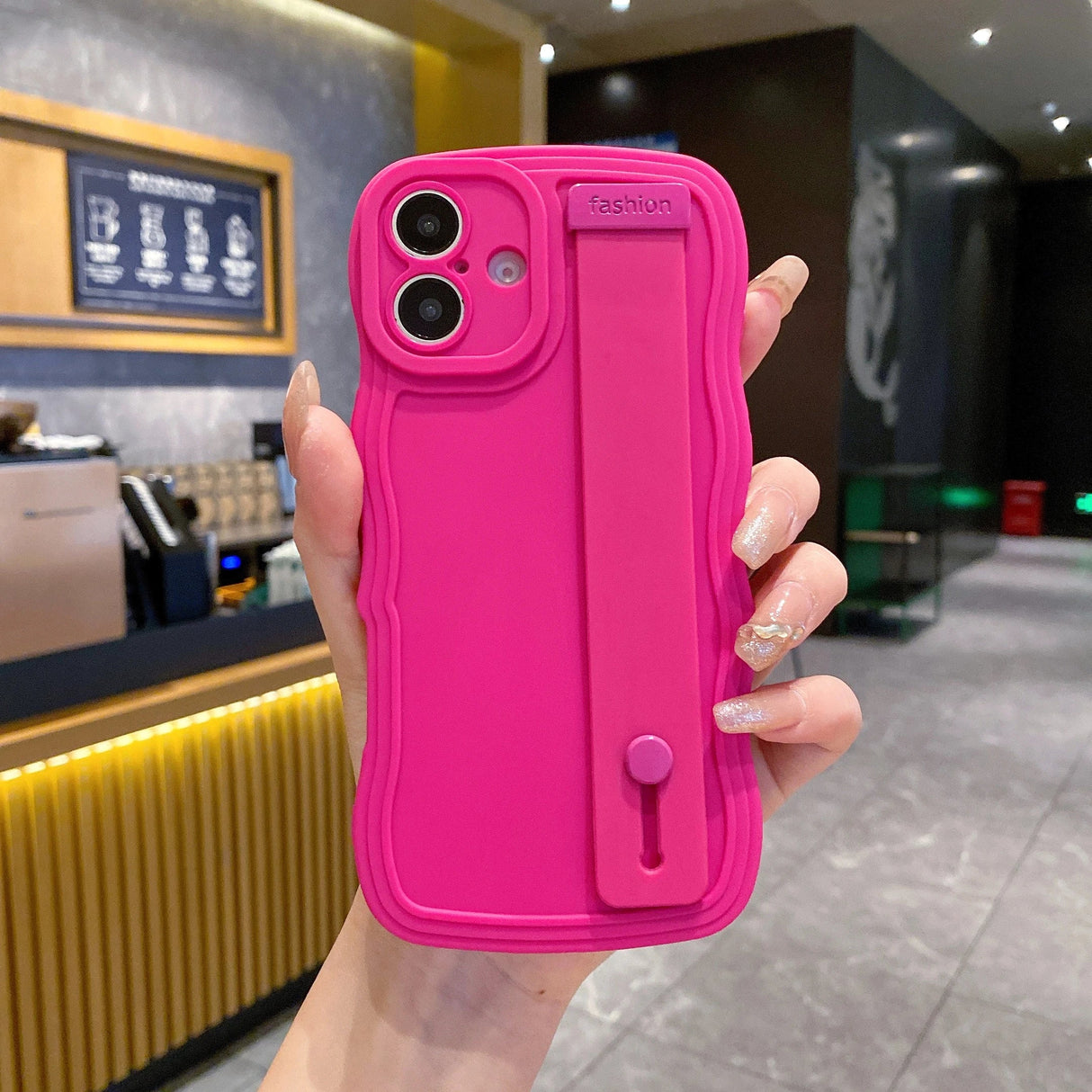 Bright pink phone case with hand strap.