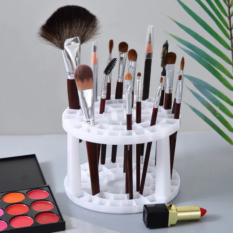 a white makeup brush holder with makeup brushes and a brush
