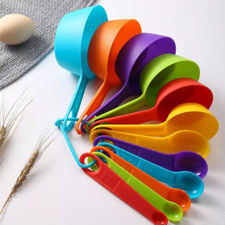 a bunch of colorful measuring spoons next to a bunch of eggs