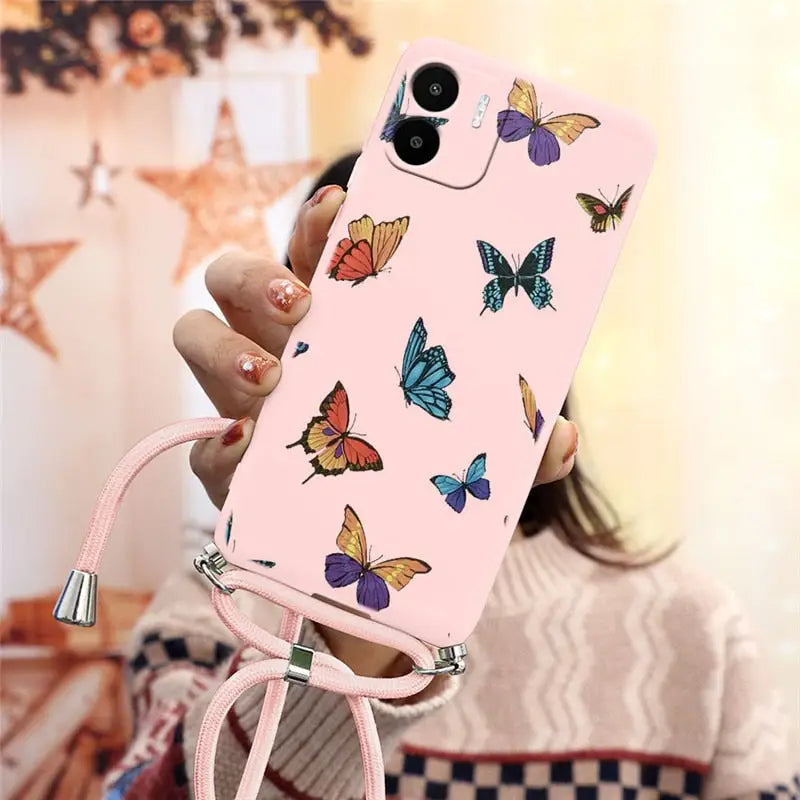 a woman holding a pink phone case with butterflies on it