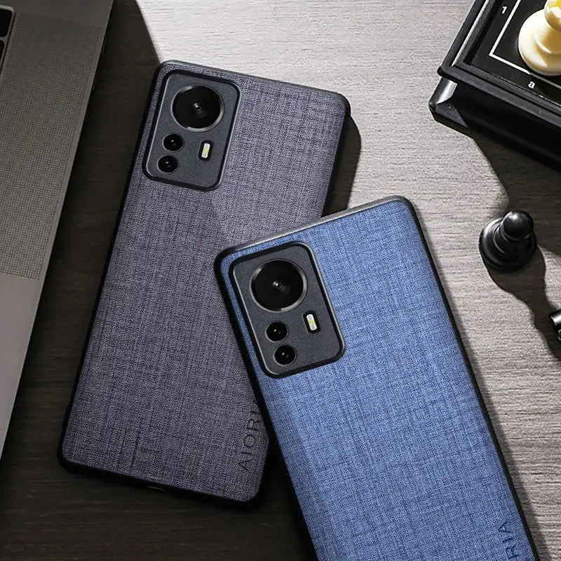 the back of a blue iphone case next to a laptop