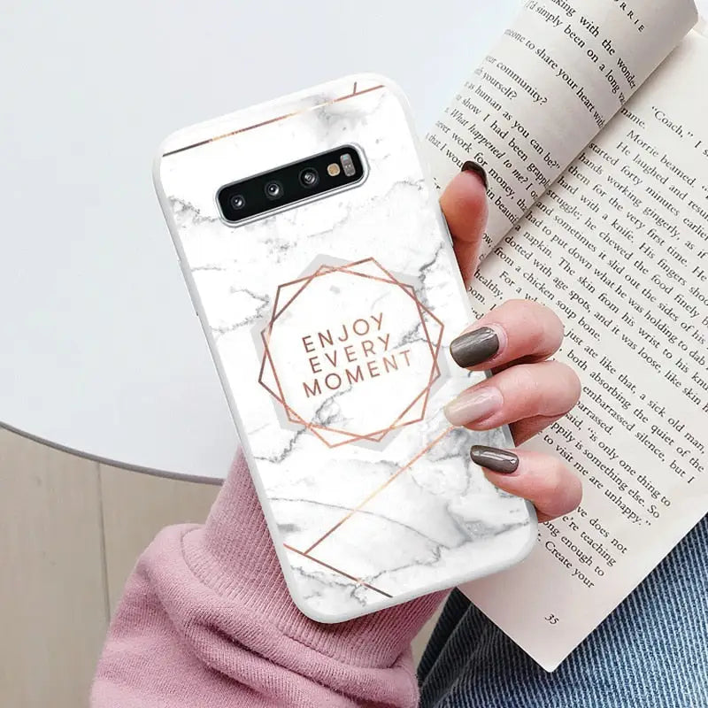 a woman holding a phone case with the words enjoy me on it