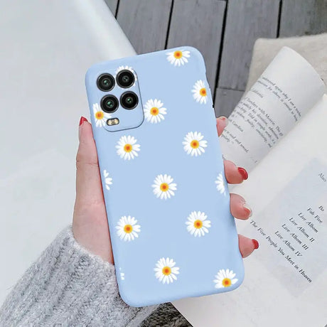 someone holding a phone case with daisies on it