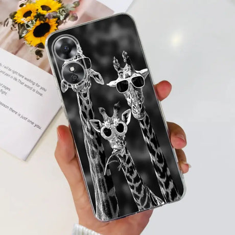 there is a person holding a phone with a picture of two giraffes