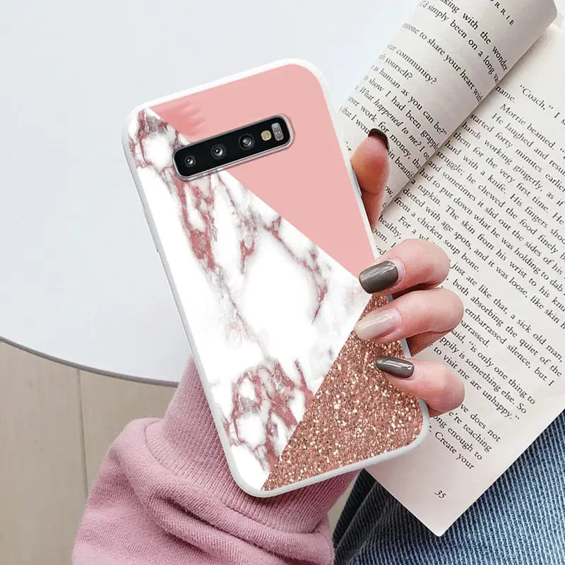 a woman holding a pink and white marble phone case