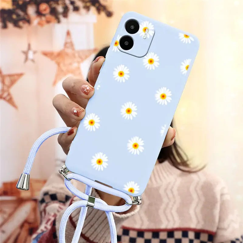 there is a woman holding a phone with a daisy pattern on it