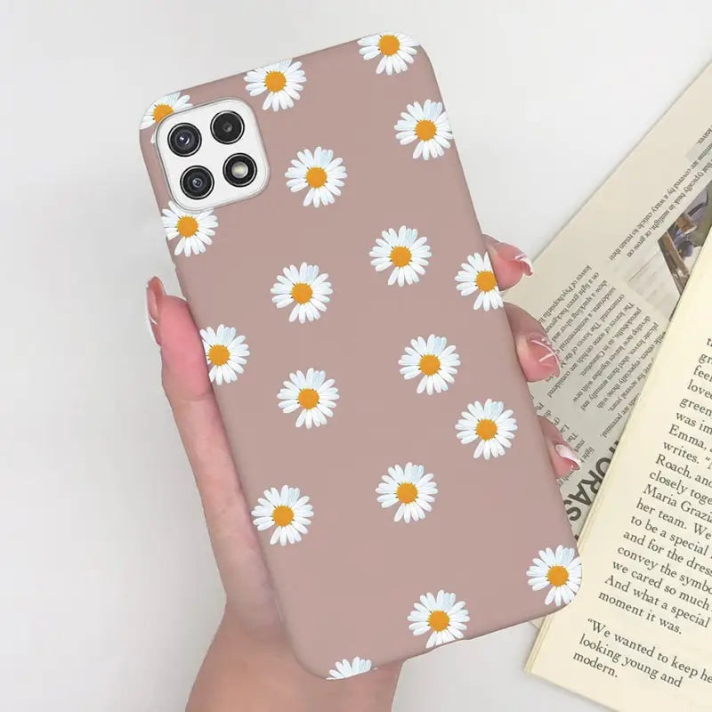 someone holding a phone case with a daisy pattern on it