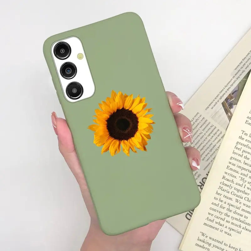 a woman holding a phone case with a sunflower on it